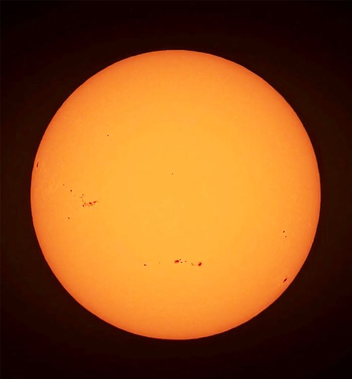A high-resolution image of the sun showing prominent sunspots, captured in East Islip, NY.